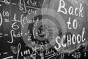 Back to school background with title `Back to school` and math formulas are written by white chalk on the black chalkboard.