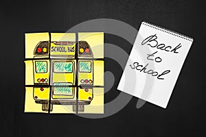 Back to school background with title `Back to school` and `school bus` written on the yellow pieces of paper and notebook