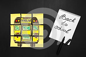 Back to school background with title `Back to school` and `school bus` written on the yellow pieces of paper and notebook photo