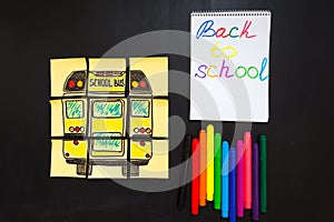 Back to school background with title `Back to school` and `school bus` written on the yellow pieces of paper, notebook with title