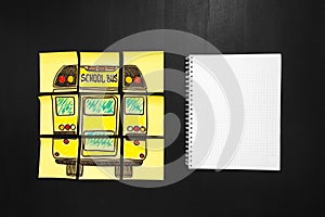 Back to school background with title `Back to school` and `school bus` written on the yellow pieces of paper and notebook photo