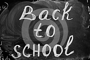 Back to school background with title `Back to school` written by white chalk on the black chalkboard.