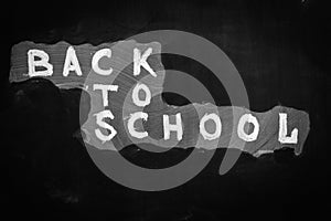 Back to school background with title `Back to school` written by white chalk on the black chalkboard