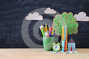 Back to school banner. tree of knowledge and pencils in front of classroom blackboard.