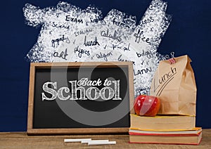 Back to school blackboard on Desk foreground with blackboard graphics of school subjects