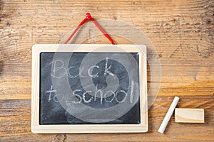 Back to school on blackboard with frame hanging on wooden wall