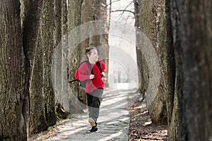 Back to school. A boy in a red sweatshirt with a backpack on his back runs down the avenue. Happy childhood in school