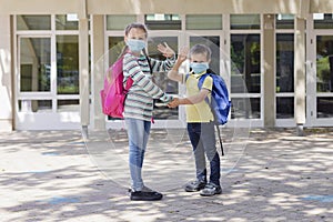 Back to school. Brother and sister, girl and boy with school backpacks go to study after a pandemic, quarantine or coronavirus.
