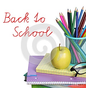 Back to school concept. An apple, colored pencils and glasses on pile of books isolated on white background.