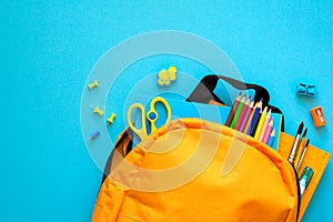 Back to school concept. Backpack with school supplies. Top view. Copy space. Toned