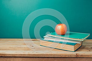 Back to school concept with books and apple on wooden table