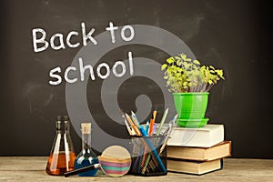 Back to school concept - books on the desk over the blackboard