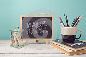 Back to school concept with books, pencils in cup and chalkboard