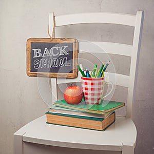 Back to school concept with books, pencils in cup and chalkboard