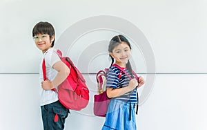 Back to school for concept. Boy and girl school children with backpack standing in white classroom