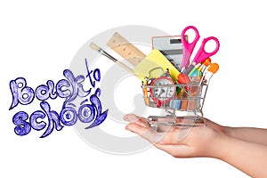 Back to school concept. Bright stationery items in a mini supermarket trolley in hand isolated on white background.