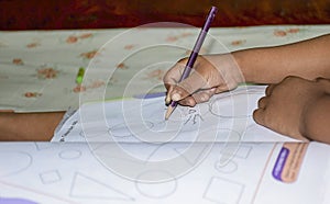 Back to school concept- a child drawing on some clouring book with oil pastle,creon colours as a  subject of study and school not