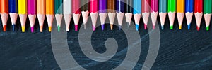Back to School concept. Color pencils on blackboard background.