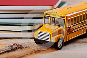 Back to school concept, colored pen, copybook, toy yellow school bus wood background