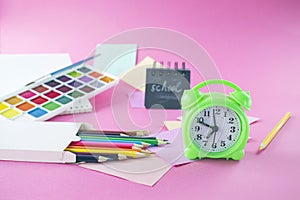 Back to school concept with colored pencils, stickers, alarm clock and notepad