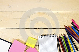Back to school concept - colorful pencils and notebook, sticky note on wooden table