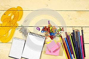 Back to school concept - colorful pencils and notebook, sticky note on wooden table/