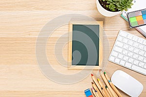 Back to school concept with copy space for flat text, top view, chalkboard mockup on wooden table. Board with school supplies