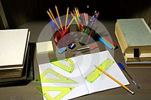 Back to school concept with empty checkered exercise book for homework, pen, pensil, compass, ruler, setsquares, protractor,