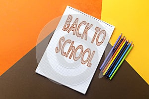 back to school concept, empty notebook and colorful pencil isolated on colorful paper background. photo