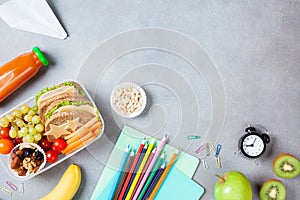 Back to school concept. Healthy lunch box and colorful stationery on table top view.