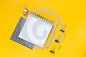 Back to school concept notepad, pencil case, stationery and school supplies. Top horizontal view copyspace yellow background