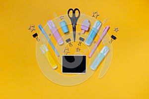 Back to school concept notepad, pencil case, stationery and school supplies. Top horizontal view copyspace yellow background