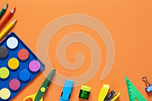 Back to school concept. School and office supplies on the office table. Orange background.Flat lay