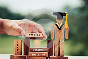 Back to School Concept, People Sign wood with Graduation celebrating cap on wooden square blocks tower blur hands. Space for