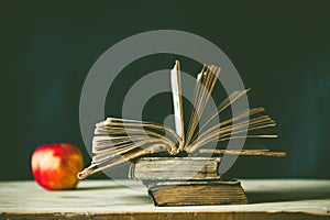 back to school concept pile of books against chalkboard