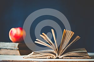 back to school concept pile of books against chalkboard