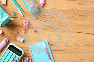 Back to school concept. Pink and turquoise colors school stationery, calculator, pencil case, paper notebook on wooden desk table