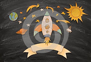 Back to school concept. rocket, space elements shapes cut from paper and painted over classroom blackboard background.