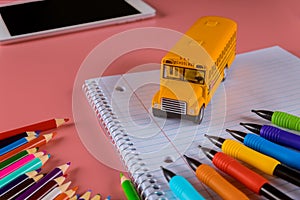 Back to school concept, school bus on notebook and pencils