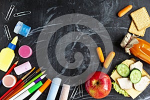 Back to school concept. School lunch, stationery on blackboard background. Top view with copy space