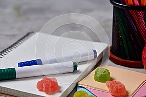 Back to School concept, school supplies, biscuits, packed lunch and lunchbox over white chalkboard, selective focus.