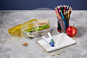 Back to School concept, school supplies, biscuits, packed lunch and lunchbox on white desk, selective focus, close-up.