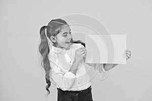 Back to school concept. Schoolgirl pupil show poster. Schoolgirl hold poster copy space. News information promotion