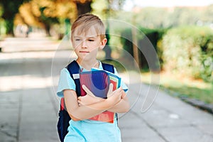 Back to school concept. Smart schoolboy holding books outdoors. Education and elementary school