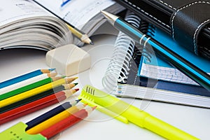 Back to school concept, supplies, multicolored pencils, notepads, highlighter, pen, textbook, rubber, white desktop, learning