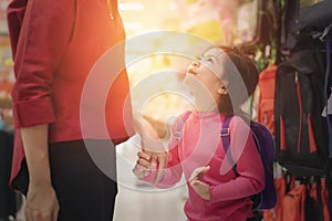 Back to school concept, Young asian mother or parent and little girl kid  buying school satchel or bag in store, Selective focus