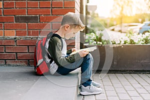 Back to school. Cute child with backpack, holding notepad and training books. School boy pupil with bag. Elementary