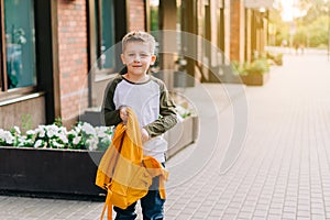 Back to school. Cute child packing backpack, holding notepad and training books going to school. Boy pupil with bag