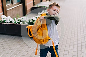 Back to school. Cute child packing backpack, holding notepad and training books going to school. Boy pupil with bag