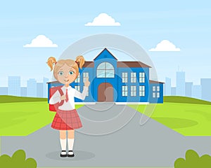 Back to School, Cute Elementary School Girl Student in Uniform Standing in front of School Building and Waving her Hand